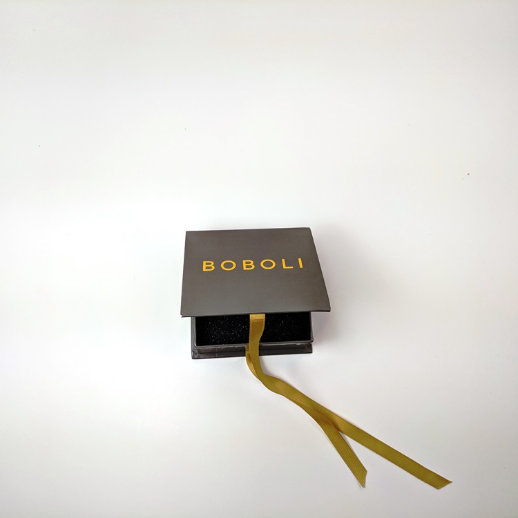Rigid box with ribbon closure